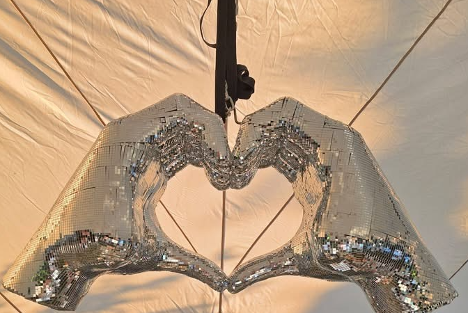 Mirrored heart-hands disco ball hung in the marquee