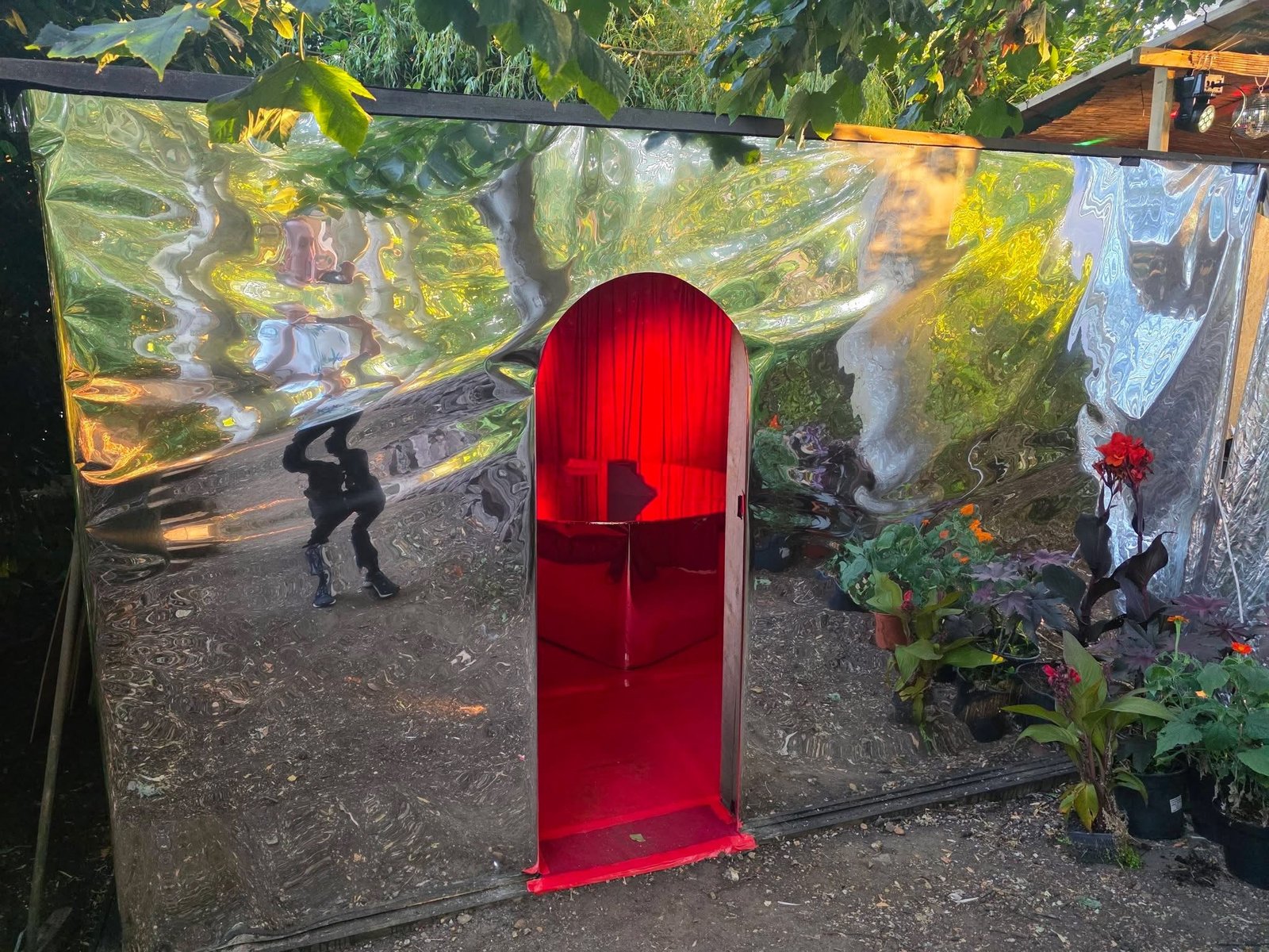 Mirrored wall with a red velvet arched doorway into the speakeasy